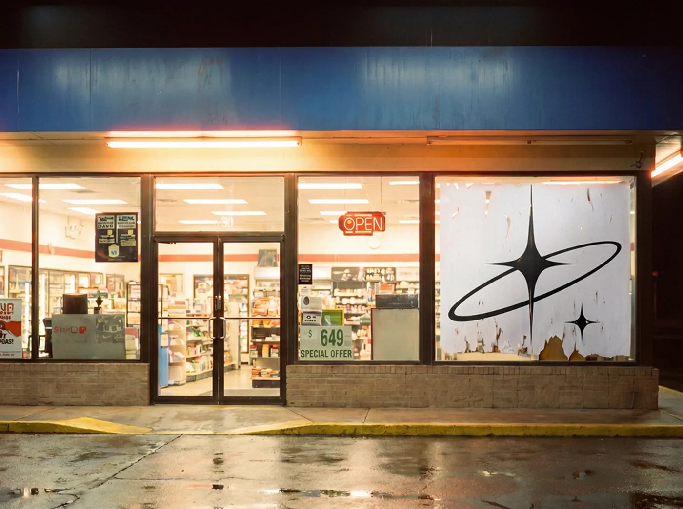 A late-night convenience storefront, the mark bleaching and peeling off a poster in the lit window.